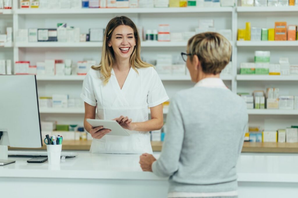 pharmacist-selling-medications-at-drugstore-to-a-senior-woman-customer